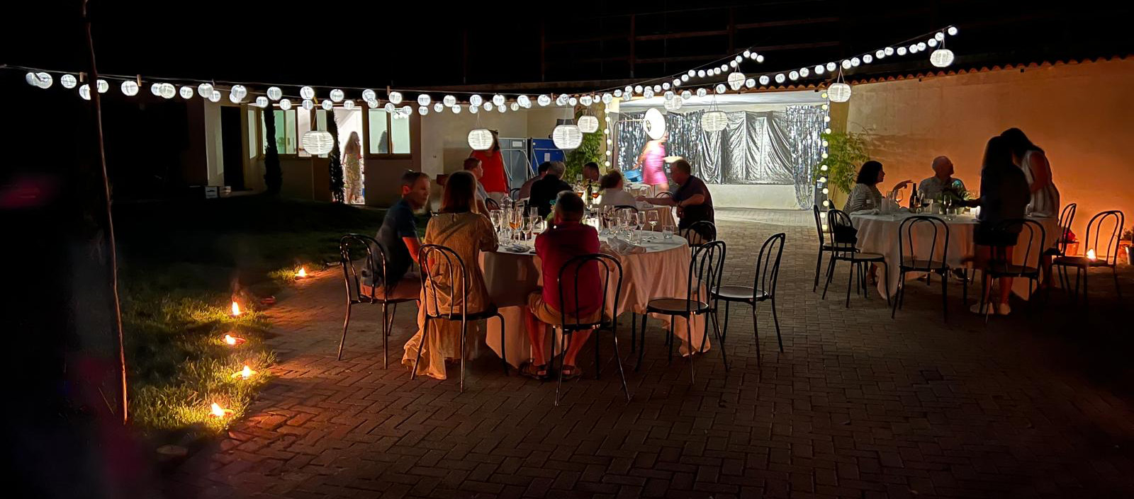 Photo of an evening party with hanging lights and a soft atmosphere